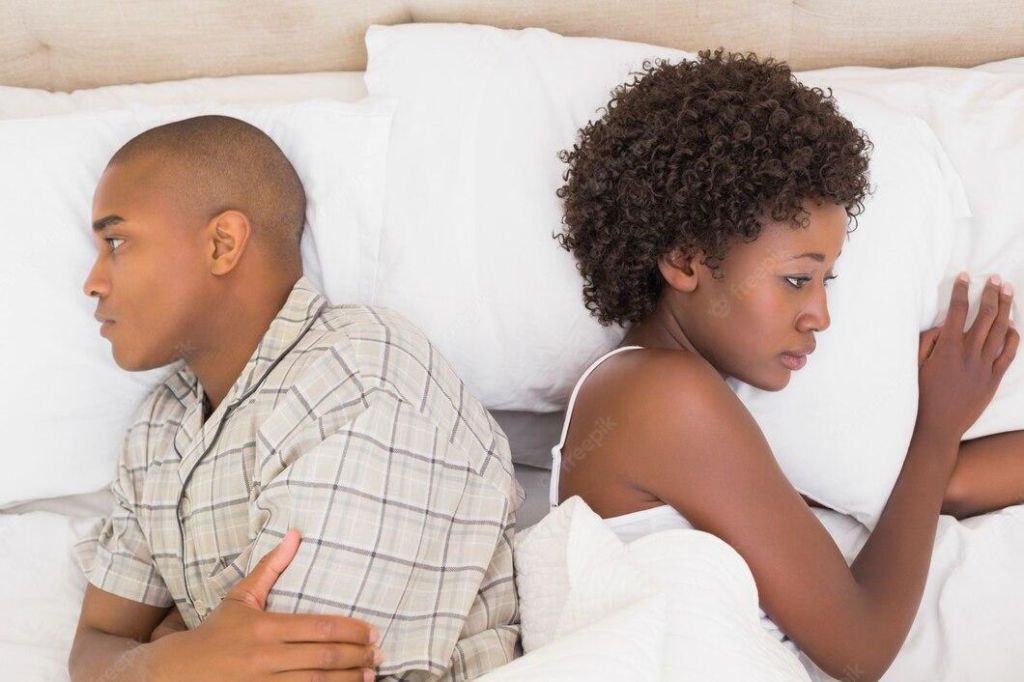 couple backing themselves on a bed